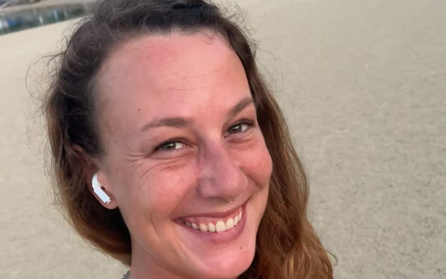 Sarah lächelt am Strand im Sonnenuntergang